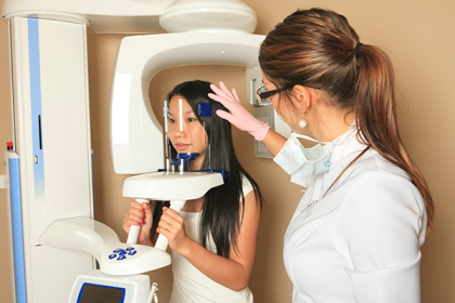 Patient and dental assistant using a 3D cone beam machine at Placentia Oral Surgery in Placentia, CA