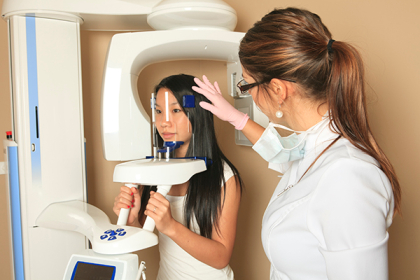 Patient and dental assistant using a 3D cone beam machine at Placentia Oral Surgery in Placentia, CA