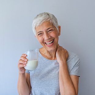 Older female patient smiling and laughing after dental implant surgery from Placentia Oral Surgery in Placentia, CA