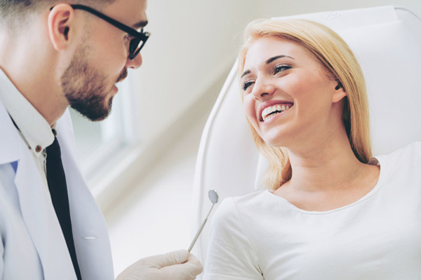 Woman smiling while oral surgeon talks from Placentia Oral Surgery in Placentia, CA